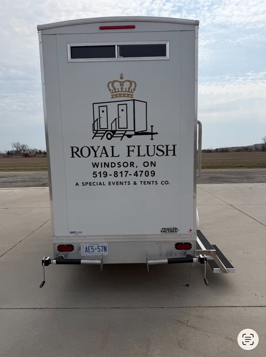 Rear view of the Royal Flush Windsor restroom trailer with Ontario license plate and branded signage